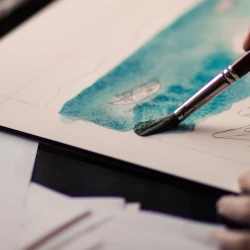 Wet paint being put down onto a thick paper suitable for watercolour painting